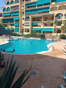 una gran piscina frente a un edificio en Apartamento en la playa, en La Mata