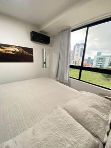 - une chambre avec un lit et une grande fenêtre dans l'établissement Flat alugue a Bessa, à João Pessoa