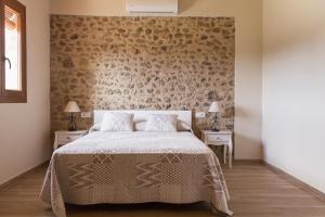 a bedroom with a bed and two tables with lamps at Mas&iacute;a Rural Can Poch in Pals