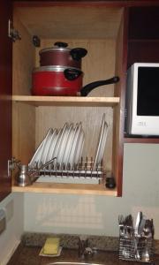 a kitchen shelf with a bunch of utensils on it at بورتو ساوث بيتش in Ain Sokhna