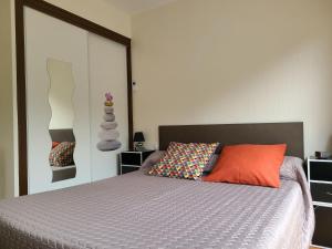 サン・ブリューにあるMeublé classé 3 étoilesのベッドルーム1室(オレンジ色の枕付きのベッド1台付)