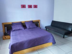um quarto com uma cama e um sofá em MC Location em Abidjan