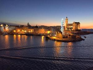 a city at night with lights on the water at Dimora Alba sul Mare in Trani