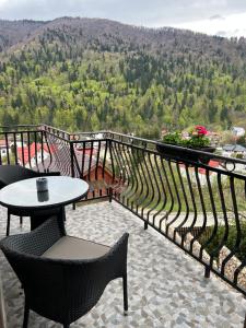 d'un balcon avec une table et des chaises et une vue. dans l'établissement Casa TimEva Azuga, à Azuga