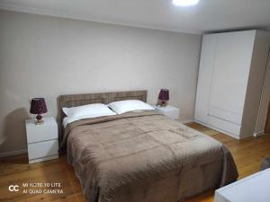 een slaapkamer met een groot bed met 2 nachtkastjes bij Tskaltubo Apartment Meri in Tskaltubo