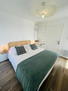 a bedroom with a large bed with a green blanket at Leptitchezsoi, calme et cosy à 5 mn du centre de Bayeux in Vaucelles