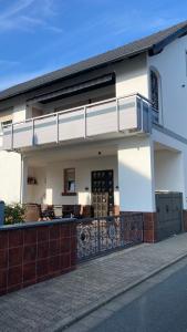 Casa blanca con balcón en una calle en Ferienwohnung -Isola Madre en Biebesheim
