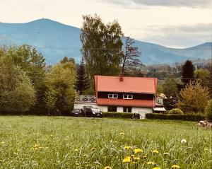 a house with a red roof in a field at Chata u Chrobáčků na Čeladné in Čeladná