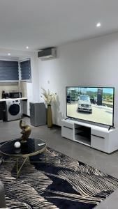uma sala de estar com uma grande televisão de ecrã plano em Nuben Court- Kumasi City em Kumasi