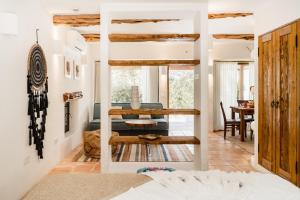 una sala de estar con paredes blancas y techos de madera. en Can Vistabella Boutique Resort, en San Antonio