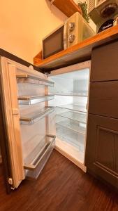 een lege koelkast met de deur open in een keuken bij Appartement T2 Rez de jardin - Disneyland Paris 6 min in Bussy-Saint-Georges