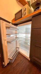 an empty refrigerator with its door open in a kitchen at Appartement T2 Rez de jardin - Disneyland Paris 6 min in Bussy-Saint-Georges +16 photos