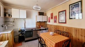 a kitchen with a table and some chairs in a room at Charming traditional mountain house in Taceno