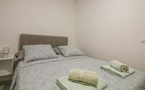 a bedroom with a bed with two towels on it at Apartman Toni in Rogoznica