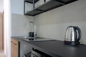 a kitchen with a sink and a tea kettle on a counter at Apartman Toni in Rogoznica