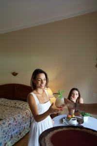 a woman is standing in front of a table with a plate of food at Hotel La Mision in San Ignacio de Velasco