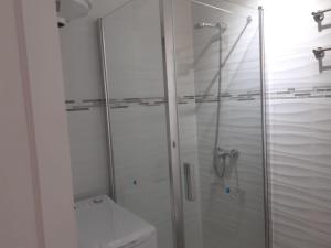 a white bathroom with a shower and a toilet at Apartamento PinkFloyd im Palm Garden in Morro del Jable