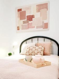 a bed with a wooden tray on top of it at Appartamento Garden in Riccione