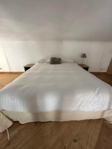 a large white bed in a room with two tables at Charmant studio centre ville Cannes in Cannes