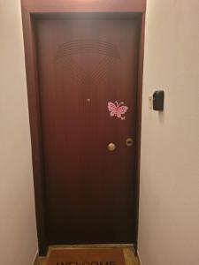 una porta marrone con un adesivo rosa a farfalla di Irene house tenis club a Ágios Rókkos