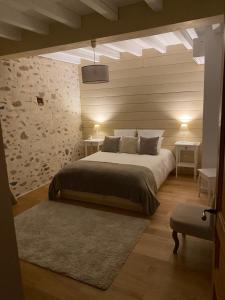 a bedroom with a large bed and two tables at Domaine des pierres trouvées in Saint-Vincent