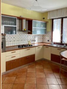 una cucina con mobili marroni e bianchi e un tavolo di Chilli House a Sottomarina