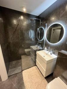 y baño con ducha, lavabo y espejo. en Apartment Studio Morena, en Gdansk