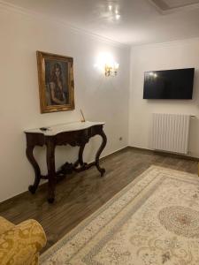 le 4 stelle luminose في Trinitapoli: غرفة معيشة مع طاولة وتلفزيون