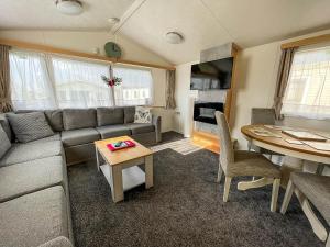 6 Berth Staycation Caravan Nearby Clacton-on-sea In Essex Ref 26254e في كلاكتون أون سي: غرفة معيشة مع أريكة وطاولة