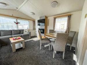 6 Berth Staycation Caravan Nearby Clacton-on-sea In Essex Ref 26254e في كلاكتون أون سي: غرفة معيشة مع طاولة وأريكة