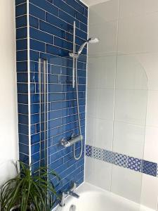 a bathroom with a shower with blue tiles at Gateway to the South Downs Near Brighton in Portslade