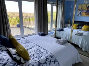 a bedroom with two beds and a large window at Gateway to the South Downs Near Brighton in Portslade