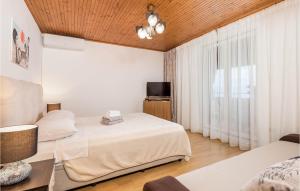 ein Hotelzimmer mit 2 Betten und einem TV in der Unterkunft Gorgeous Apartment In Lovran With Kitchen in Lovran