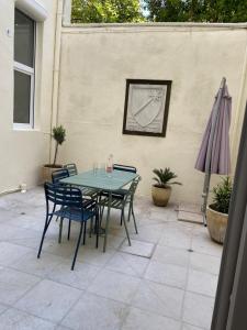 a patio with a table and chairs and an umbrella at Appartement cœur de Nimes avec cour in Nîmes