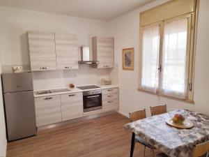 una cucina con tavolo e frigorifero di La Casera a Lido di Dante Altre 37 foto