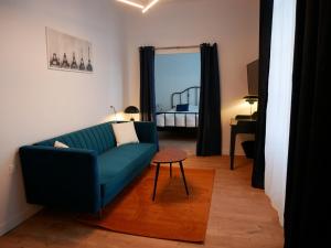 sala de estar con sofá azul y dormitorio en Clos de la Providence Chambres d'hôtes et Spa en Nolay