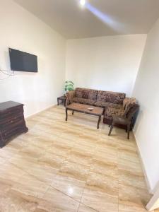 a living room with a couch and a flat screen tv at Omar home in Madaba