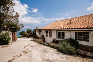 an old house with a red roof on a dirt road at Floreica Studio By The Sea in Skinária