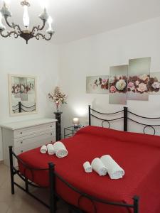 a bedroom with a red bed with white towels on it at A CASA DI MATTEO in Brugnato