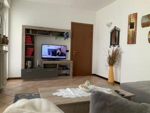 ein Wohnzimmer mit einem Sofa und einem TV in der Unterkunft CASA VACANZA DA SANDRA in Brusnengo