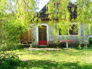 une ancienne maison en pierre avec une porte rouge dans l'établissement Maison de poupée et son SPA privatif, à Orthez
