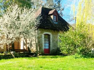 Cette petite maison en pierre est dotée d'une porte rouge. dans l'établissement Maison de poupée et son SPA privatif, à Orthez
