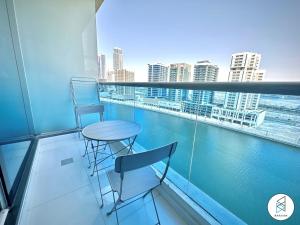 balkon z 2 krzesłami i stołem w budynku w obiekcie Apartments at Business Bay by Bhavan Vacation Homes w Dubaju