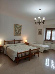 a bedroom with two beds and a chandelier at A CASA DI MATTEO in Brugnato