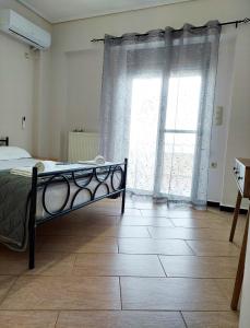 a bedroom with a bed and a large window at Golden Sunrise - Nikos Home in Gythio