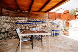 una mesa y sillas en un patio con una pared de piedra en Floreica Studio By The Sea, en Skinária