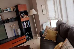 uma sala de estar com um sofá e uma televisão em Apartamento Malzapatu - 4 dormitorios - Llanes em Llanes