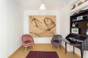 - un salon avec un piano et deux chaises dans l'établissement Casa Calderai art and design, à Palerme