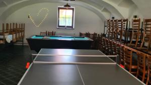a room with a pool table in a church at Ubytování Na statku 