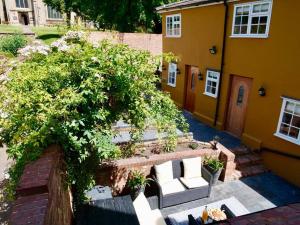 a house with two white chairs and a tree at Huge Luxury 8 Bed Manor House Hot Tub Pool Table in Saffron Walden